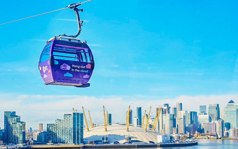 London IFS Cable Car with city skyline and O2 Arena in the background.