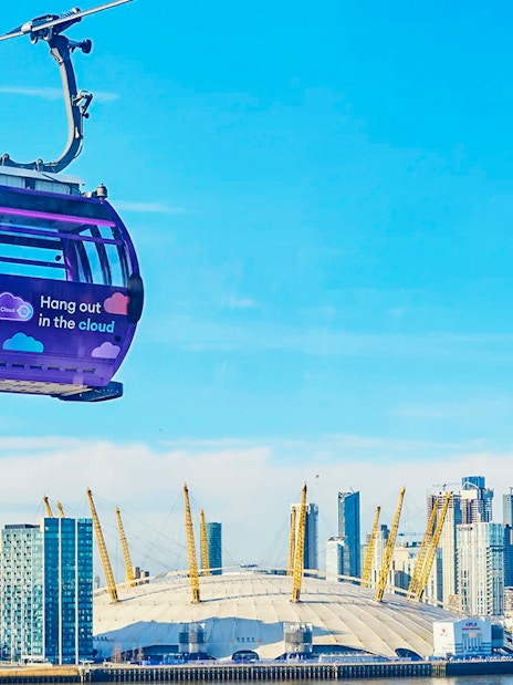 London IFS Cable Car with city skyline and O2 Arena in the background.