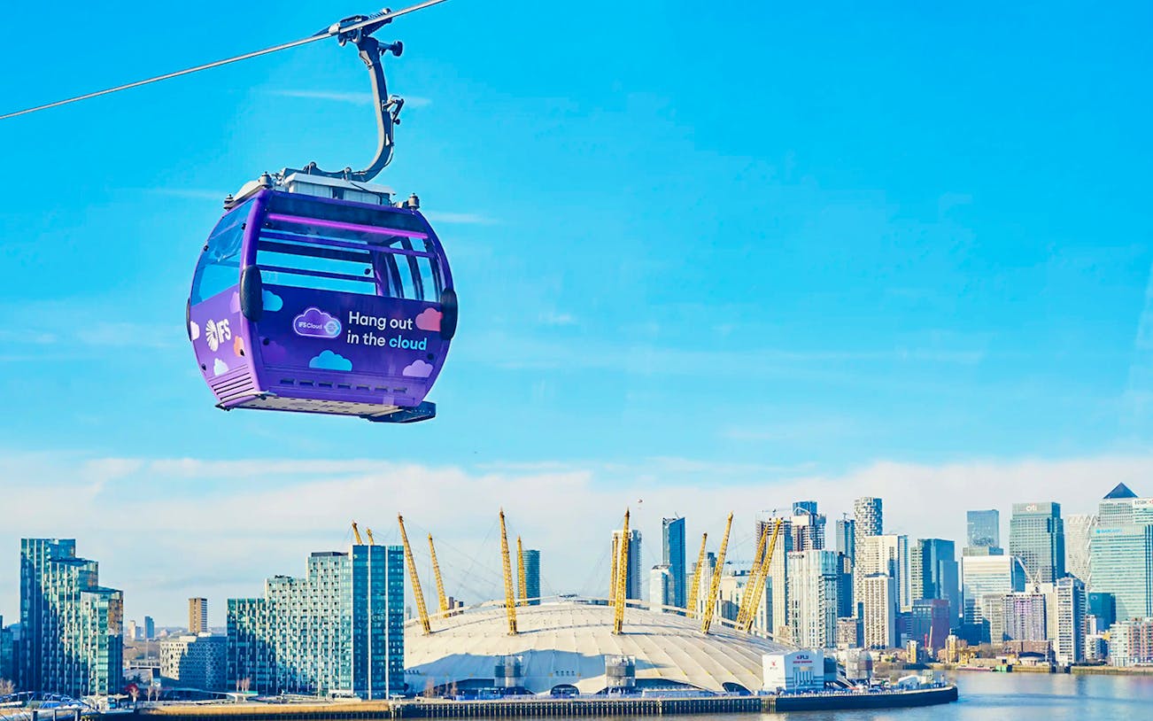 London IFS Cable Car with city skyline and O2 Arena in the background.