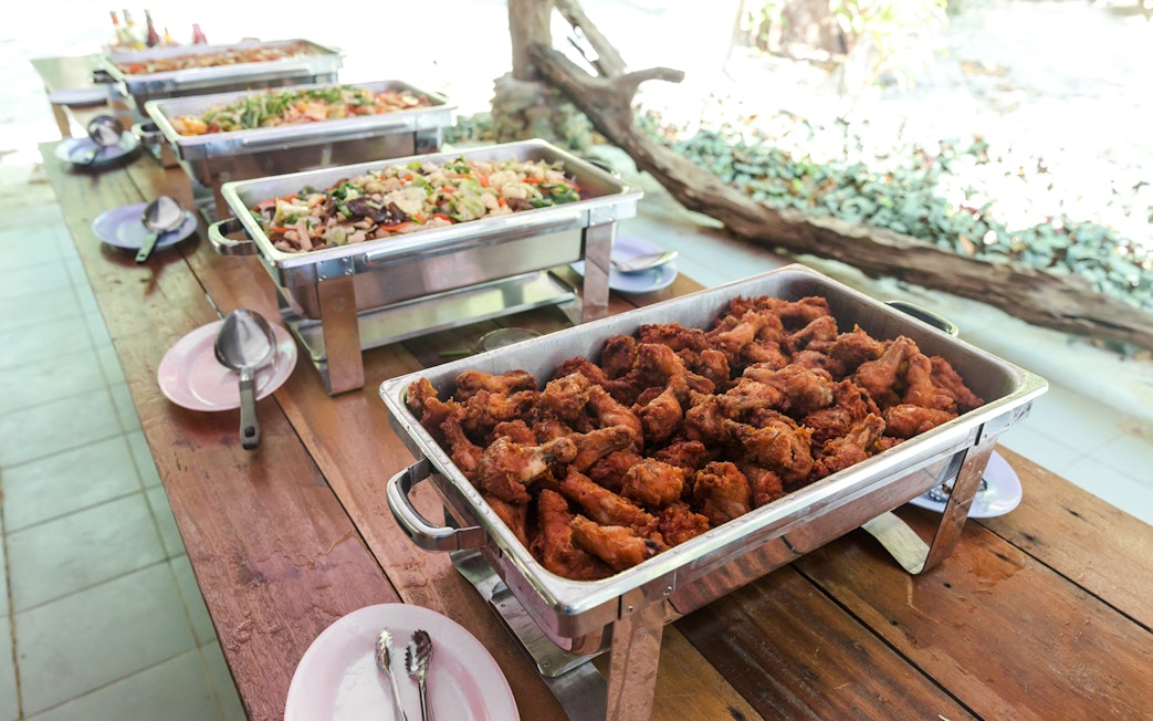 Buffet with fried chicken and assorted dishes on a wooden table.