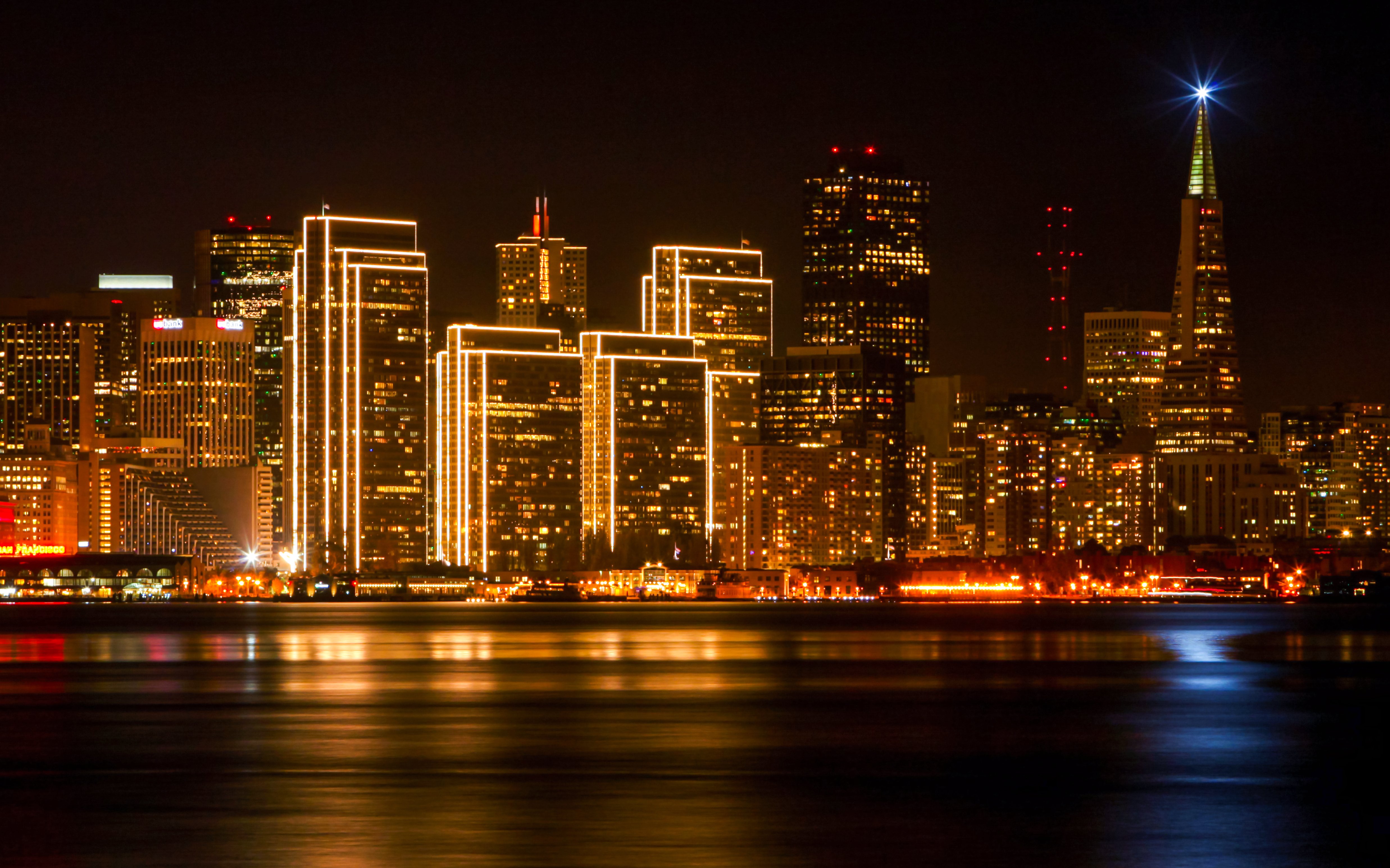San Francisco skyline at night with illuminated buildings and Transamerica Pyramid.
