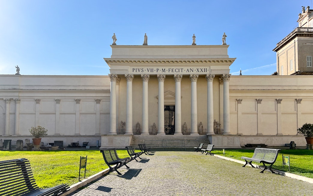 Vatican Museums entrance with columns and statues, Rome, Italy.