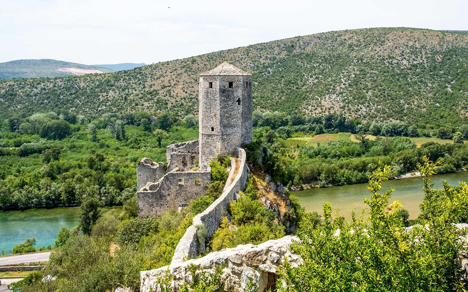 Pocitelj Citadel overlooking lush landscape and river in Bosnia and Herzegovina.