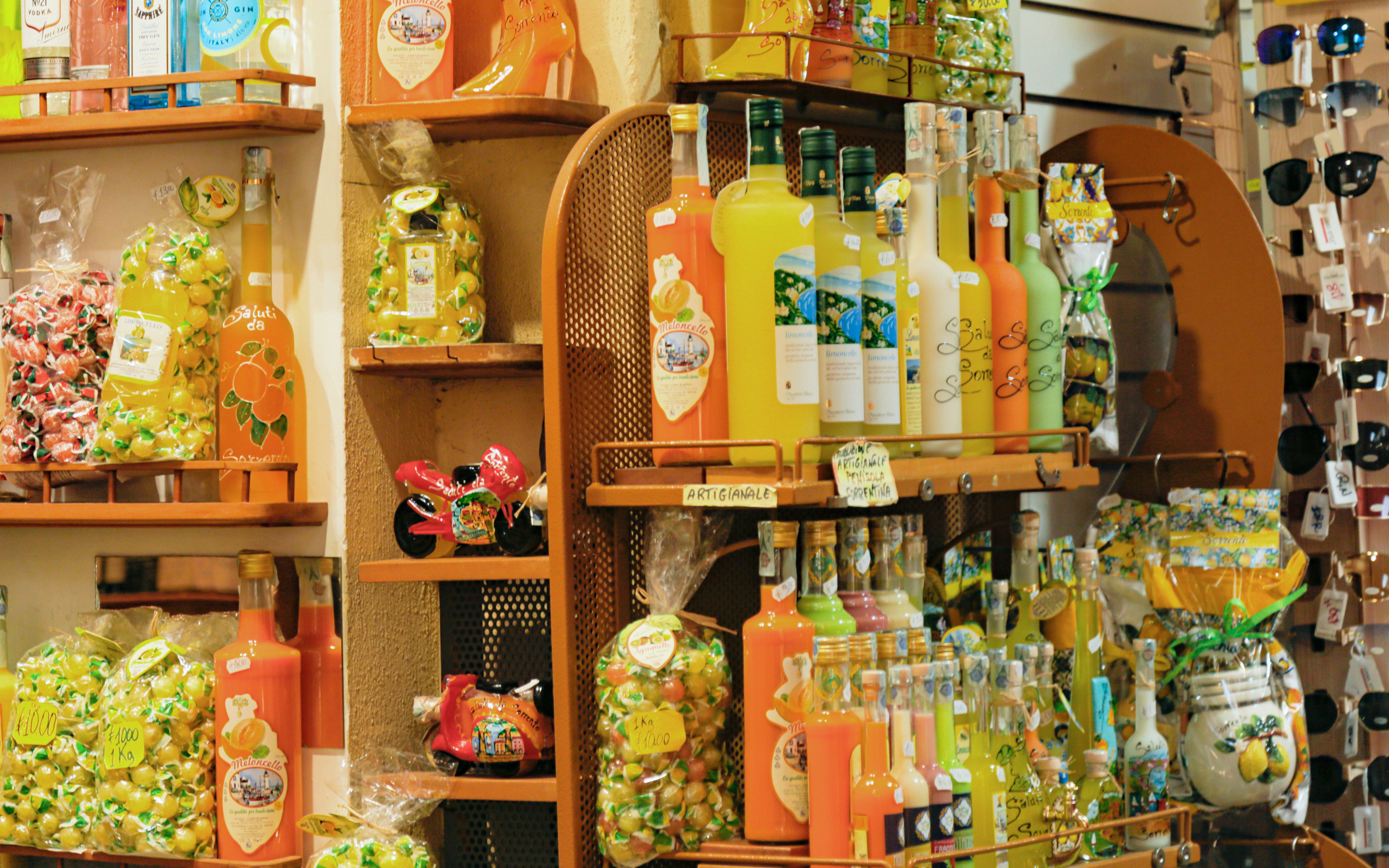 Limoncello bottles and lemon-themed souvenirs in a Sorrento shop display.