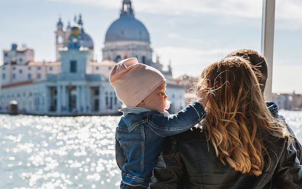 Family enjoying Venice boat tour with view of Santa Maria della Salute.