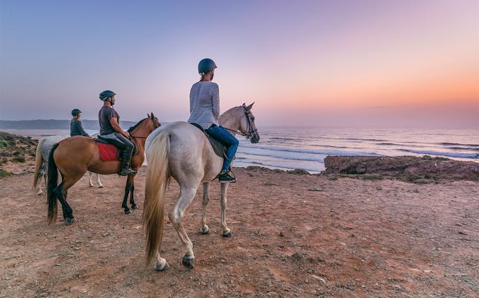 Horse riders overlooking the ocean at sunset on Carrapateira tour.