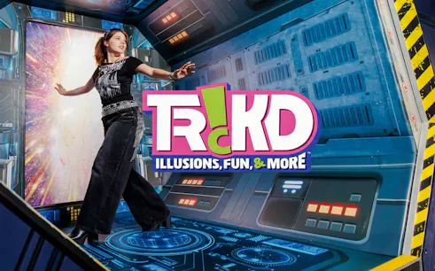 Person interacting with a space-themed illusion at TRICKD: Illusions, Fun, & More exhibit.