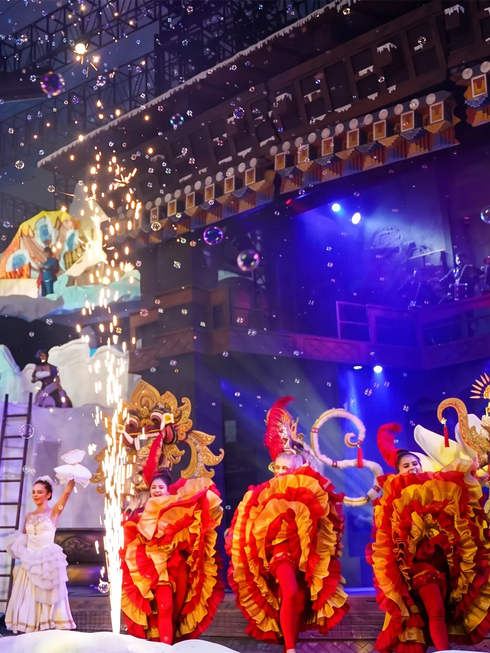 Performers in colorful costumes on stage at Trans Studio Bali.