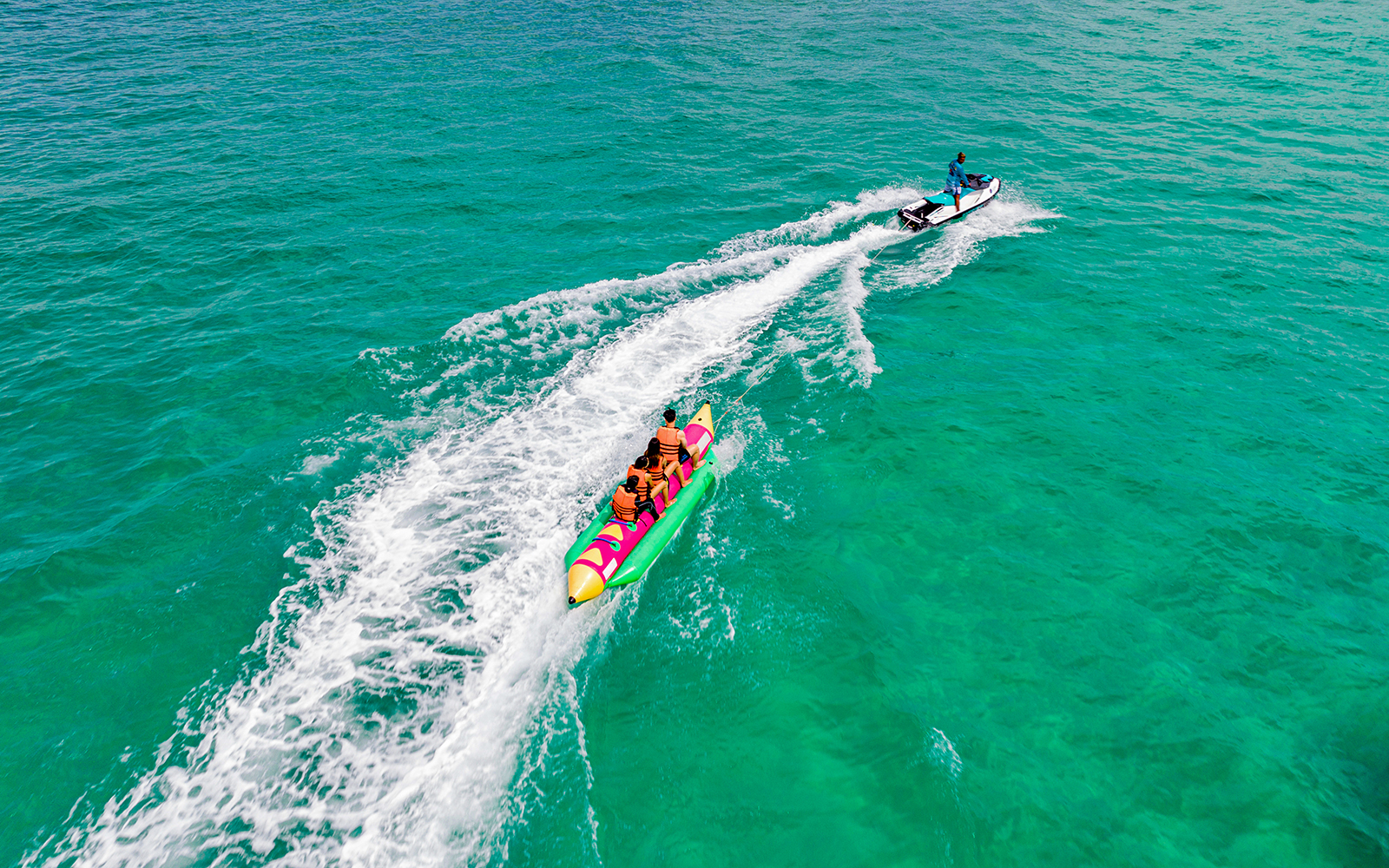 People enjoying a banana boat ride in Pattaya's turquoise waters.