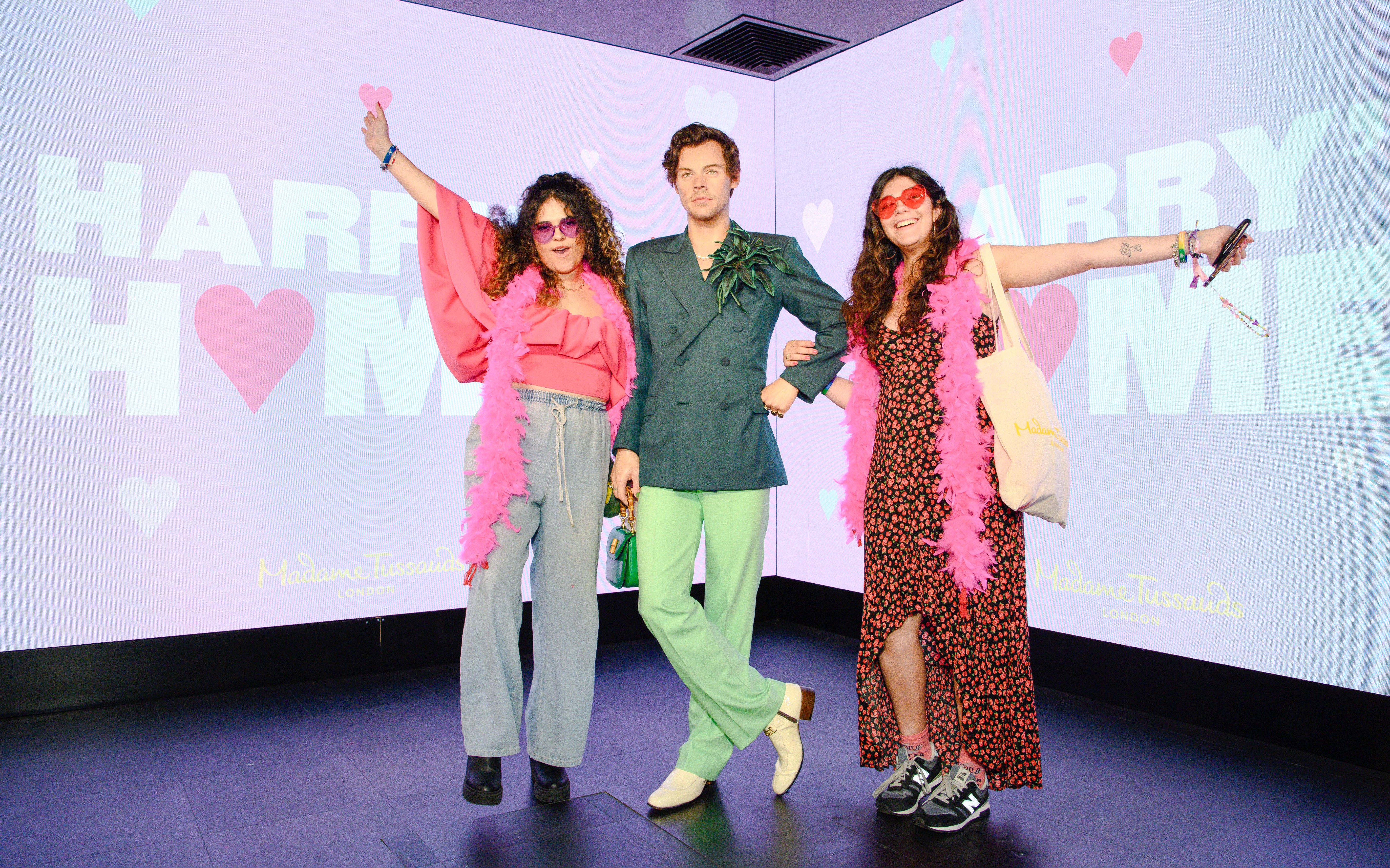 Wax figure of Harry Styles with visitors at Madame Tussauds London.