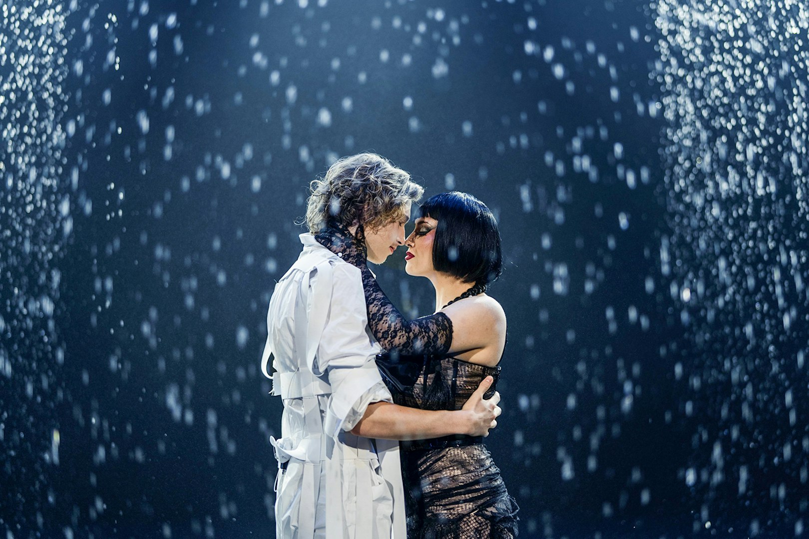 Performers embracing under stage lights at FALLING | IN LOVE Grand Show, Friedrichstadt Palast.