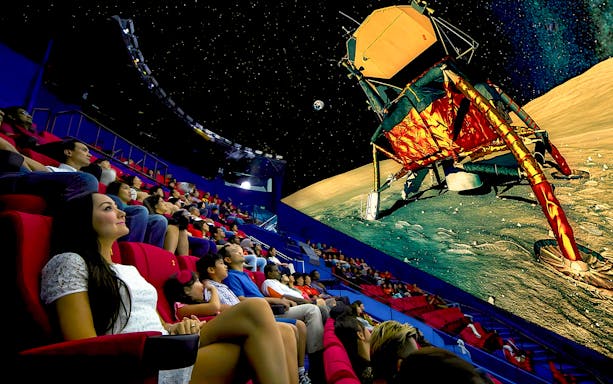 Audience watching space-themed show at Omni Theatre, Singapore.