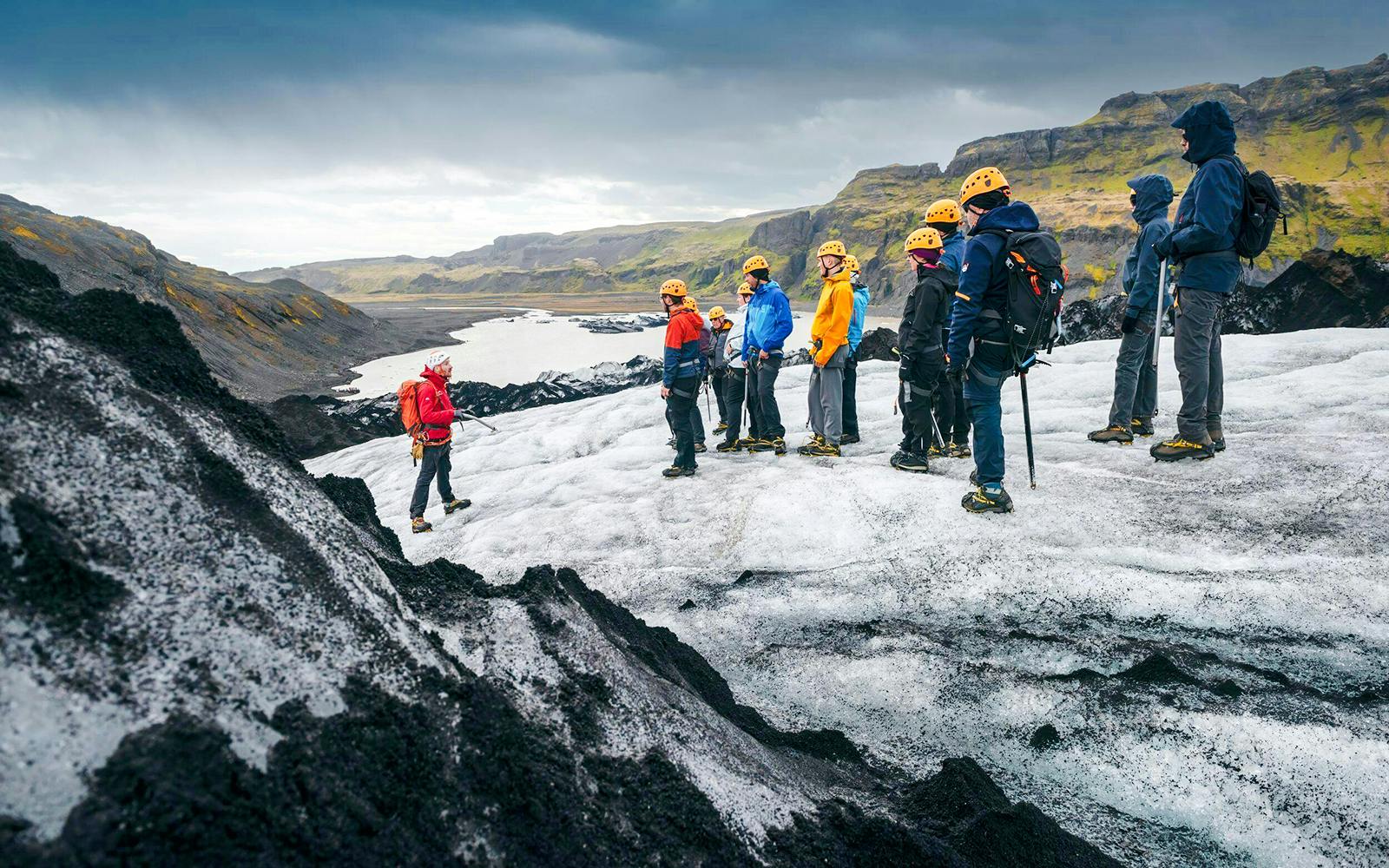 Group hiking on Solheimajökill Glacier, Iceland, with guide leading the tour.