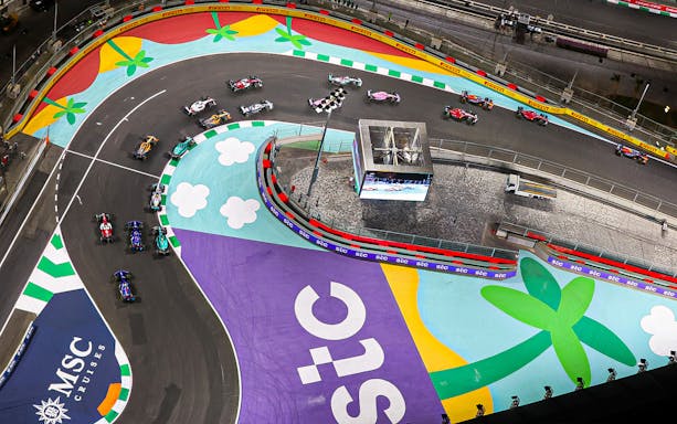 Formula 1 cars racing on a colorful track at Saudi Arabia Grand Prix, March 2023.