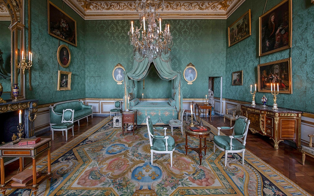 Hôtel de la Marine opulent room with green decor, chandelier, and antique furniture.