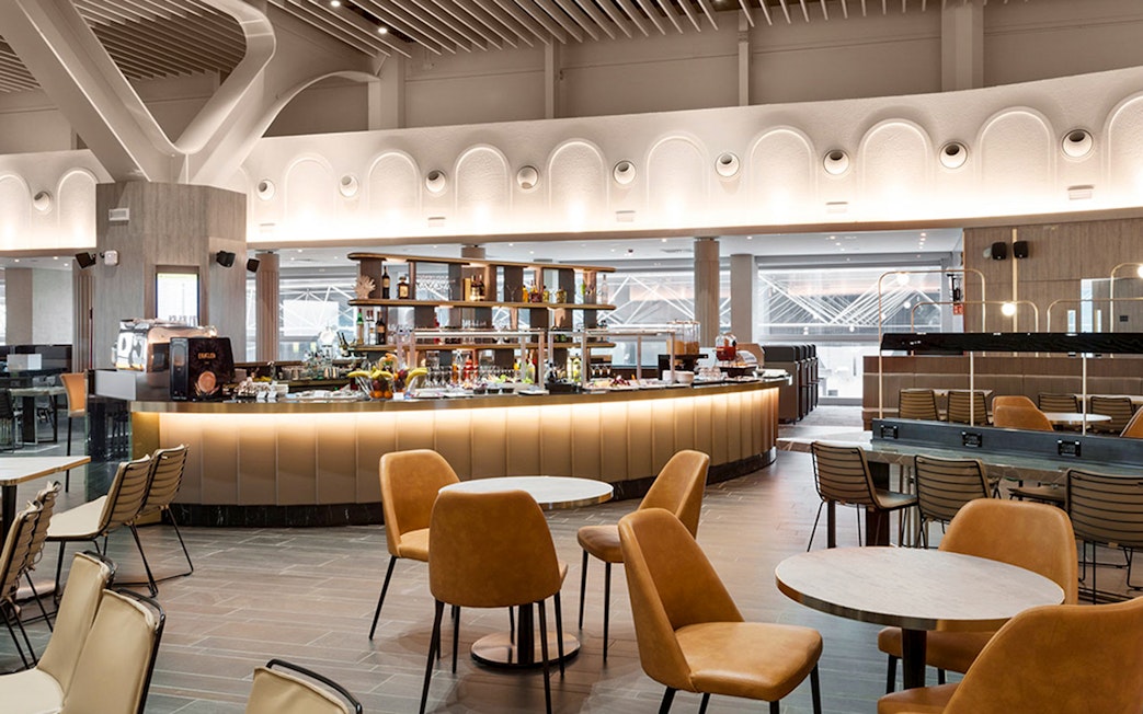 Premium lounge interior at Leonardo da Vinci-Fiumicino Airport with seating and bar area.