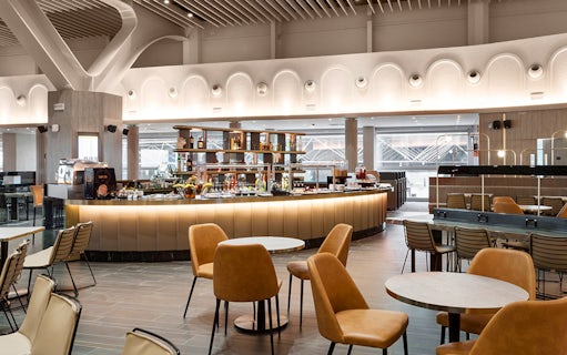 Premium lounge interior at Leonardo da Vinci-Fiumicino Airport with seating and bar area.