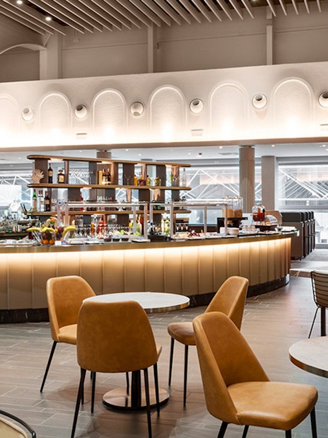 Premium lounge interior at Leonardo da Vinci-Fiumicino Airport with seating and bar area.