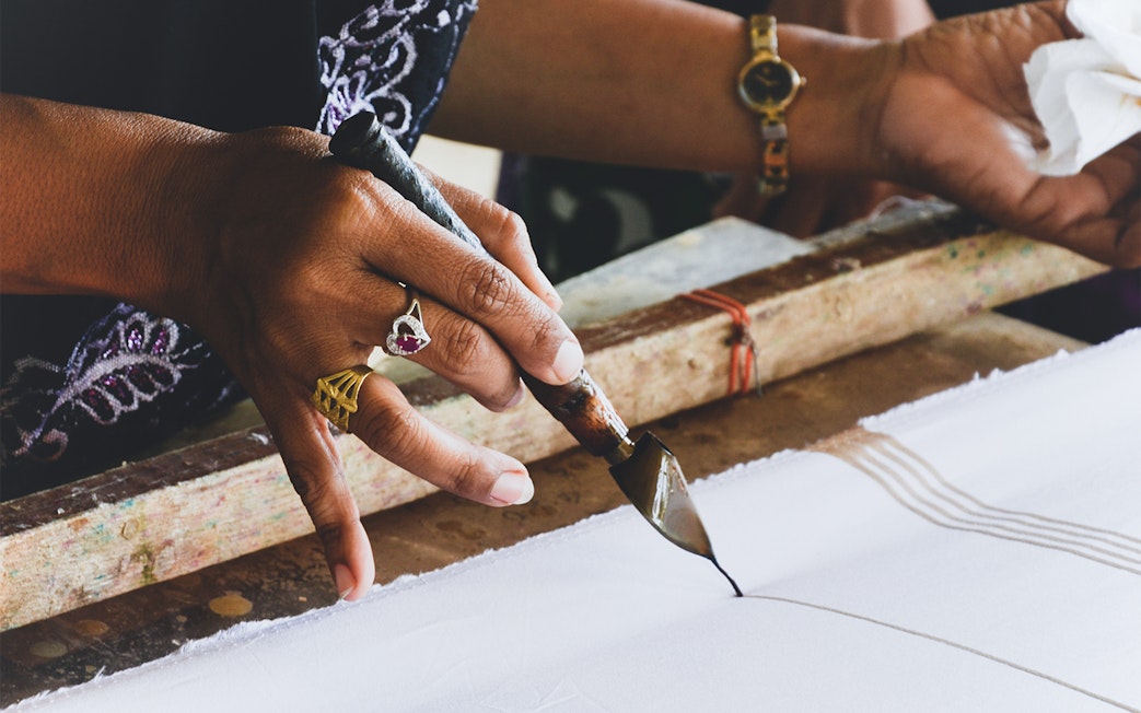 Batik painting demonstration during Batu Caves tour from Kuala Lumpur.