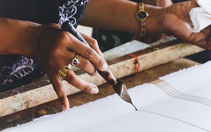 Batik painting demonstration during Batu Caves tour from Kuala Lumpur.
