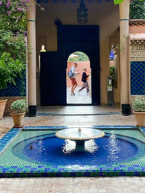 Jardin Majorelle courtyard with blue-tiled fountain and lush greenery.
