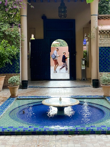Jardin Majorelle courtyard with blue-tiled fountain and lush greenery.