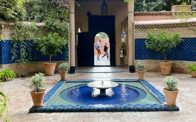 Jardin Majorelle courtyard with blue-tiled fountain and lush greenery.