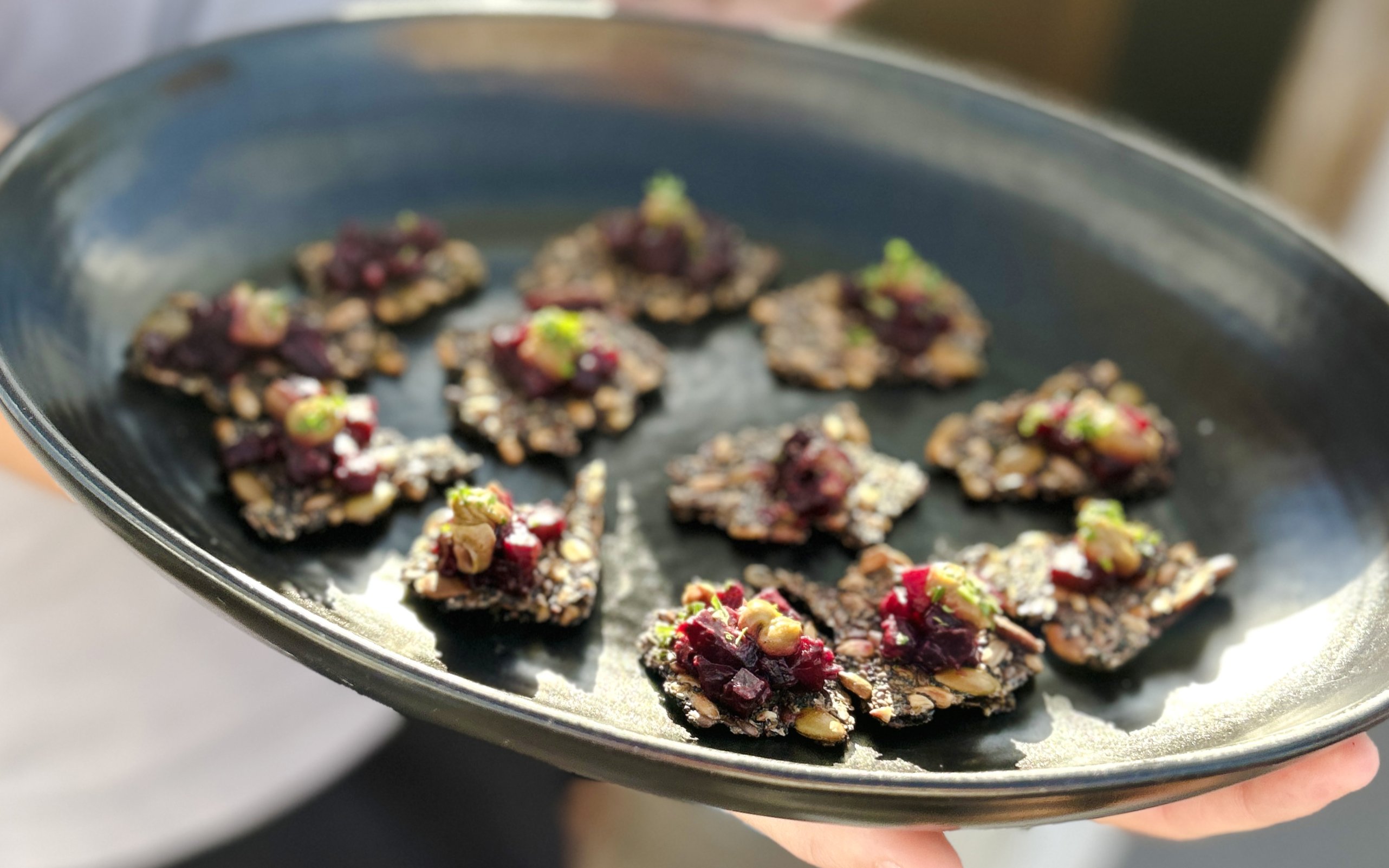 Appetizers served on a black platter during Auckland Harbour dinner cruise.