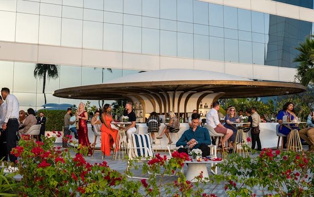 Guests enjoying drinks at Uma Lounge, Burj Al Arab, with a saxophonist performing.