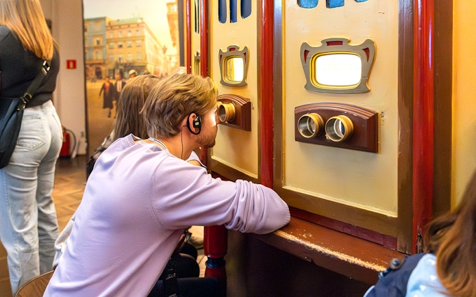 Visitor using audio guide at Oskar Schindler's Factory exhibit in Krakow, Poland.