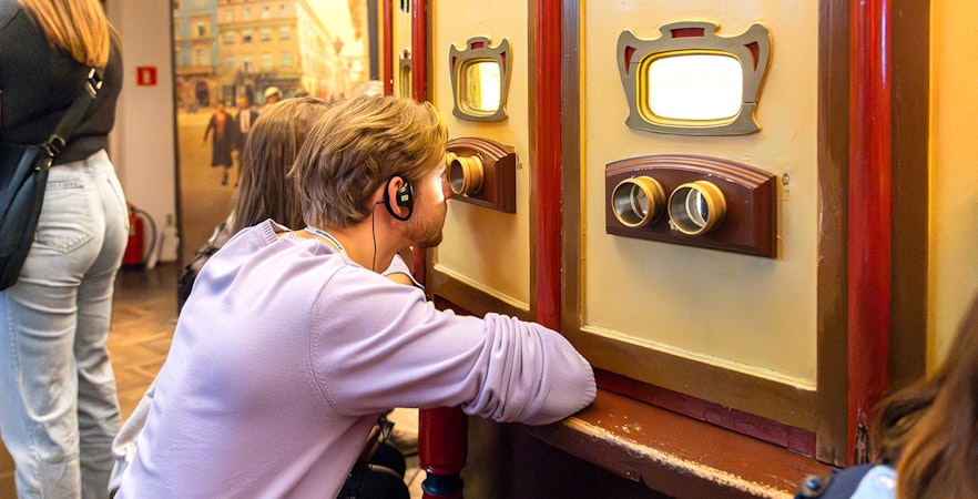 Visitor using audio guide at Oskar Schindler's Factory exhibit in Krakow, Poland.