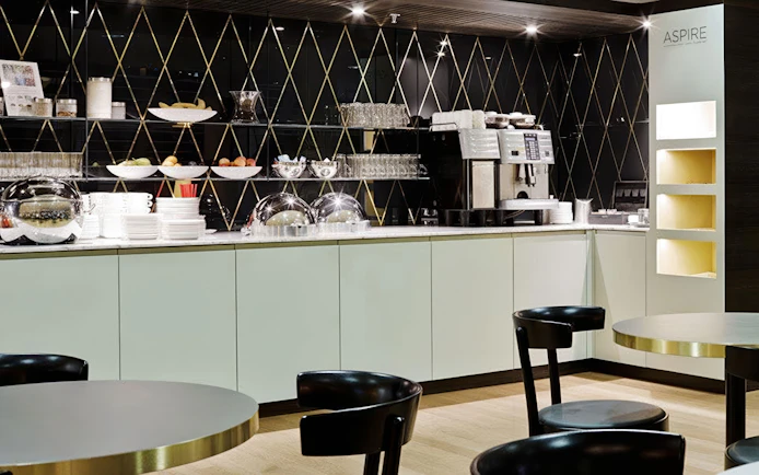 Aspire ONE Lounge Zurich Airport buffet area with coffee machine and seating.