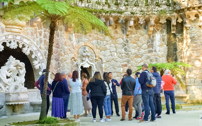 Tourists listening to a guide at Quinta de Regaleira Palace, Sintra.