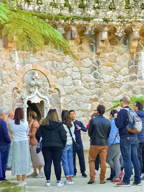 Tourists listening to a guide at Quinta de Regaleira Palace, Sintra.