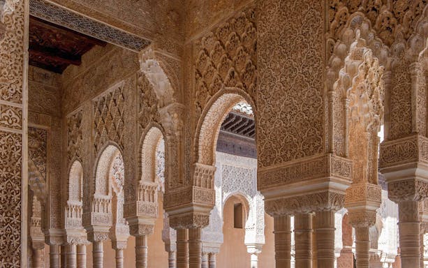 Intricate Moorish arches in the Nasrid Palaces, Alhambra, Granada.