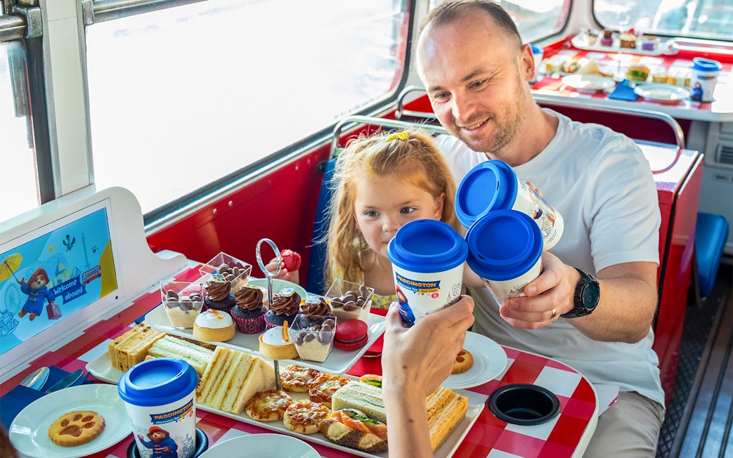 Guests enjoying afternoon tea on the Paddington Bus with sandwiches and pastries.