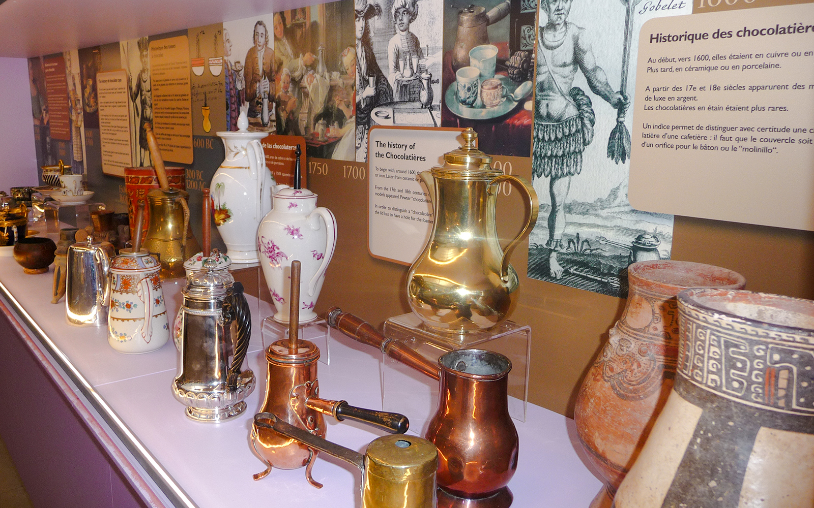 Artifacts of historical chocolate pots and vessels at Choco-Story Paris museum.