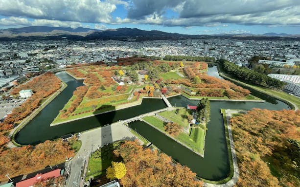 Aerial view of Goryokaku Park's star-shaped fort and surrounding cityscape in Hakodate, Japan.