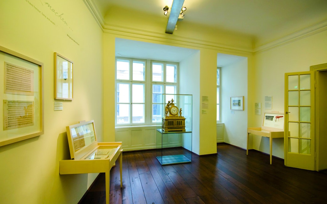 Mozart's apartment interior at Mozarthaus Vienna, featuring historical exhibits and a clock display.