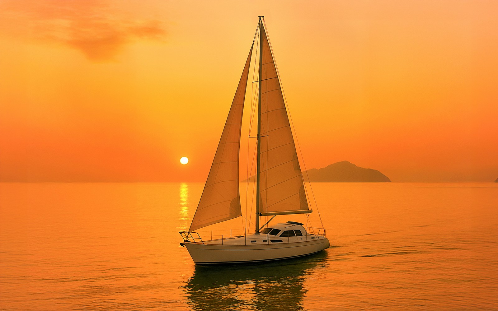 Monohull sailing in Langkawi waters with lush green hills in the background.
