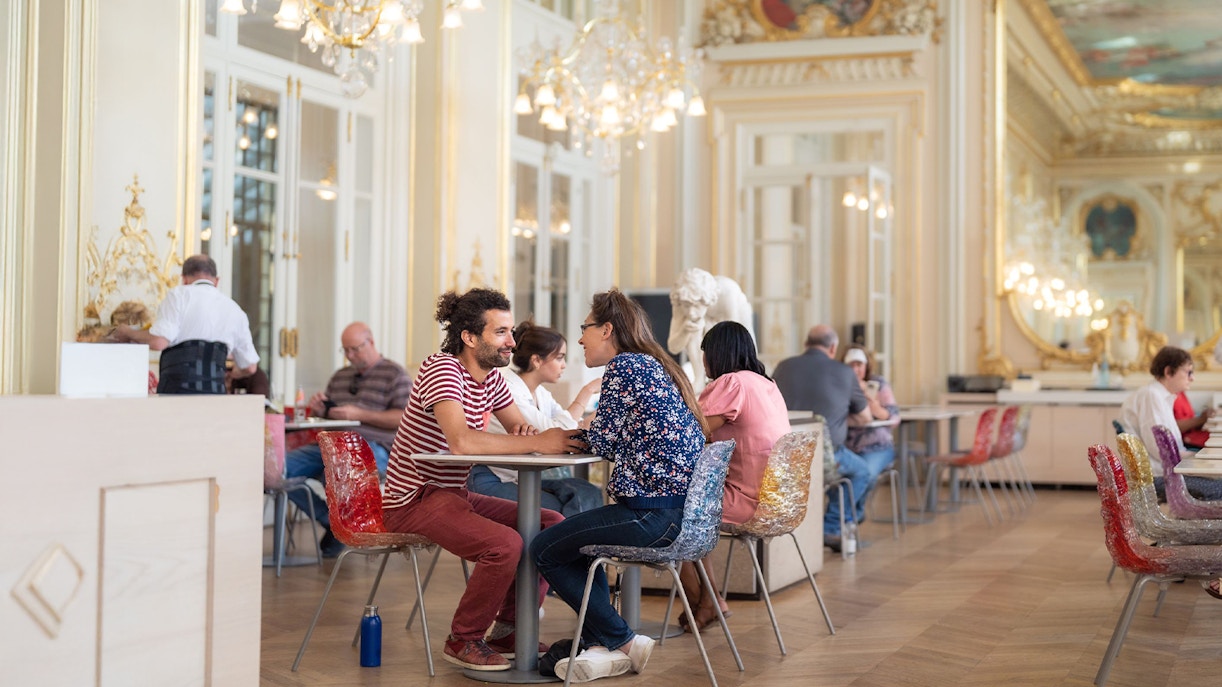 Visitors viewing Impressionist art at Musée d’Orsay, Paris, with gourmet lunch experience.