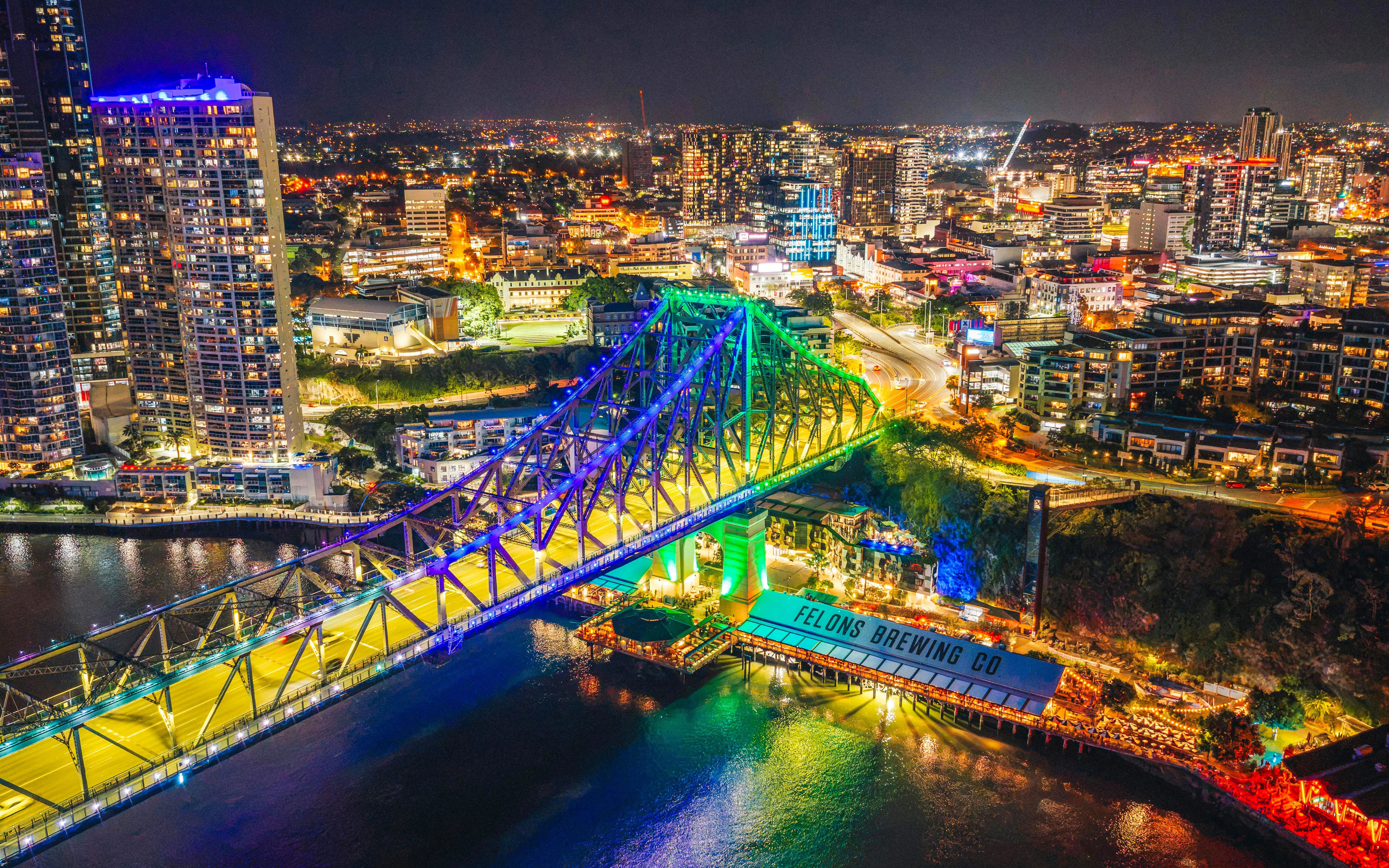 Story Bridge lit up at night in Brisbane, Australia, with city skyline in the background.