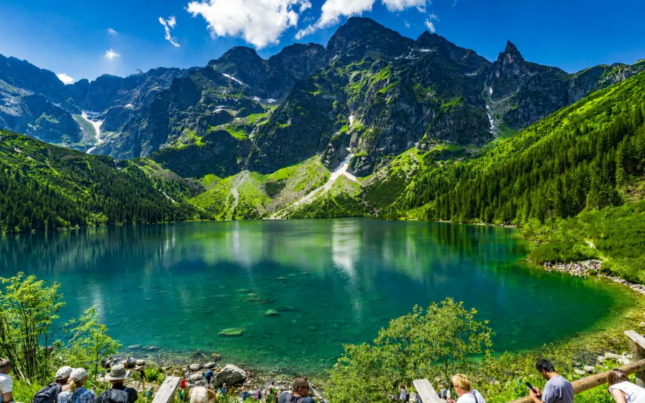 Mountain lake view in Zakopane with tourists, part of Krakow day tour including Gubałówka cable car.