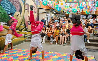 Street performers doing handstands during Comuna 13 Graffiti Tour in Medellin, Colombia.