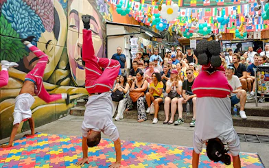 Street performers doing handstands during Comuna 13 Graffiti Tour in Medellin, Colombia.