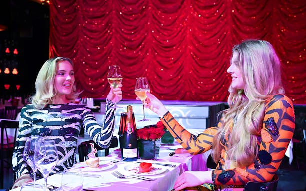 Guests toasting with Champagne at Paradis Latin cabaret in Paris.