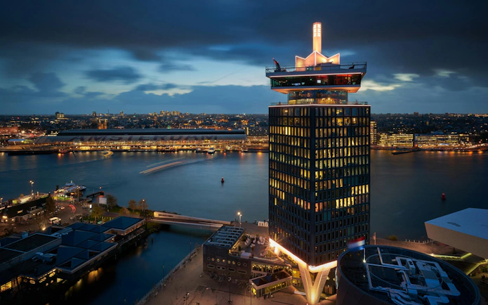 A'DAM Tower with illuminated skybar overlooking Amsterdam at night.