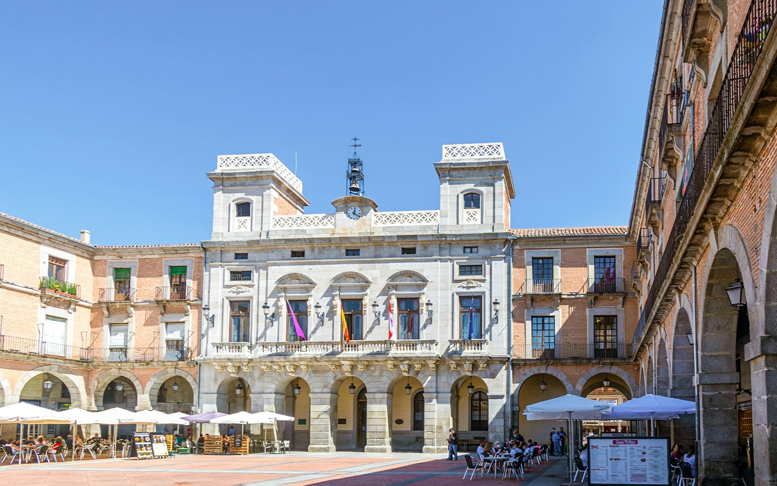 Plaza del Mercado Chico in Ávila with historic stone buildings and people exploring the square.