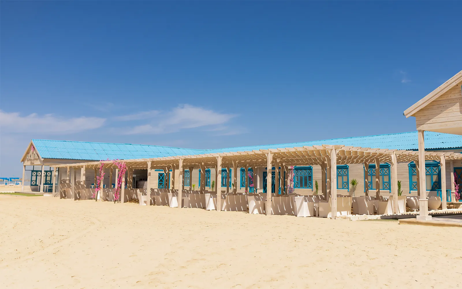 Beachfront pavilion on Bianca Island, Hurghada, with blue roof and sandy surroundings.