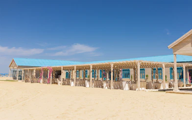 Beachfront pavilion on Bianca Island, Hurghada, with blue roof and sandy surroundings.